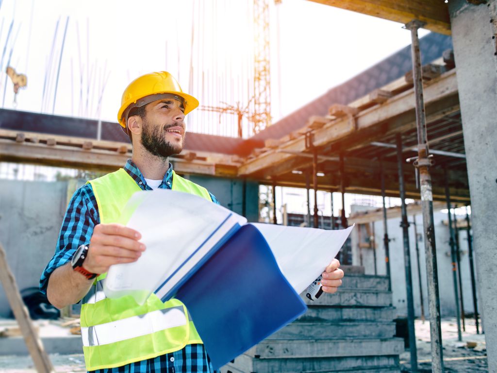 Construction worker reviewing plans - representing professional project management