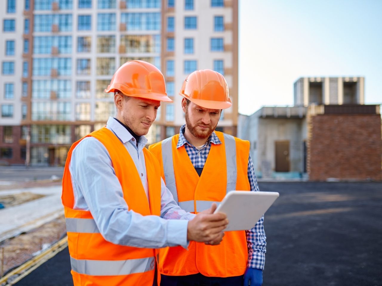 Construction workers using tablet for incident reporting in the field